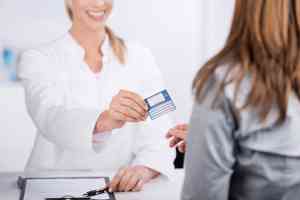 Patientin und Arzthelferin mit Versicherungskarte 